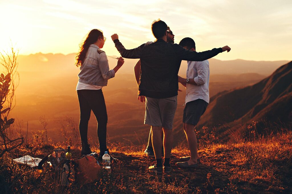 Catchy Motivational four person standing at top of grassy mountain